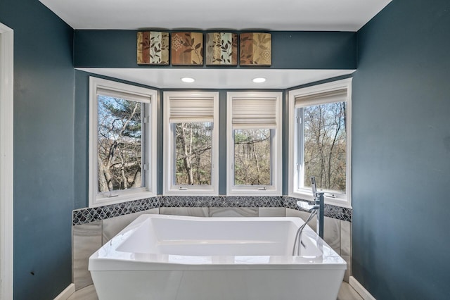 bathroom with a bath and tile walls