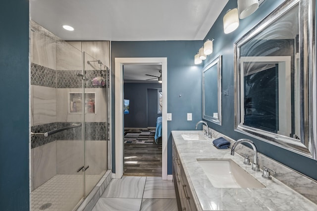ensuite bathroom with a sink, ensuite bathroom, a shower stall, and double vanity