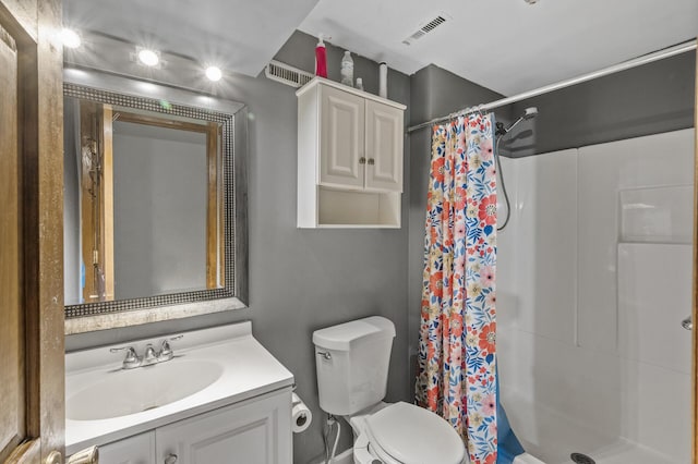full bathroom featuring vanity, toilet, visible vents, and a stall shower