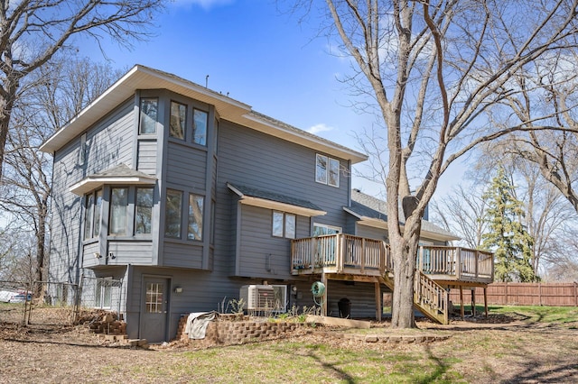 rear view of house featuring fence, a deck, a shingled roof, ac unit, and stairway