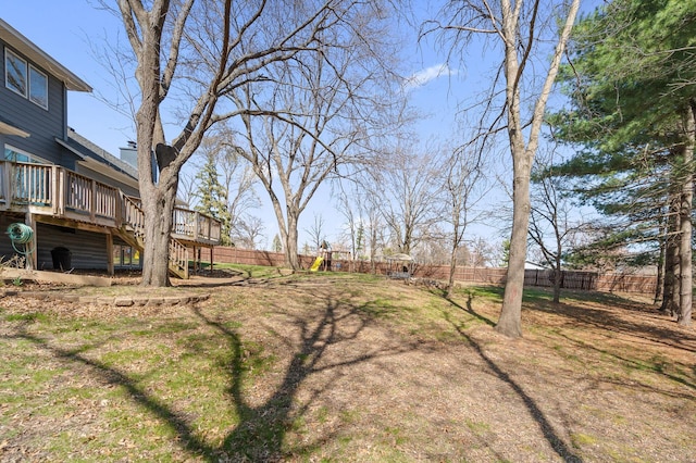 view of yard with a fenced backyard, a wooden deck, and stairs