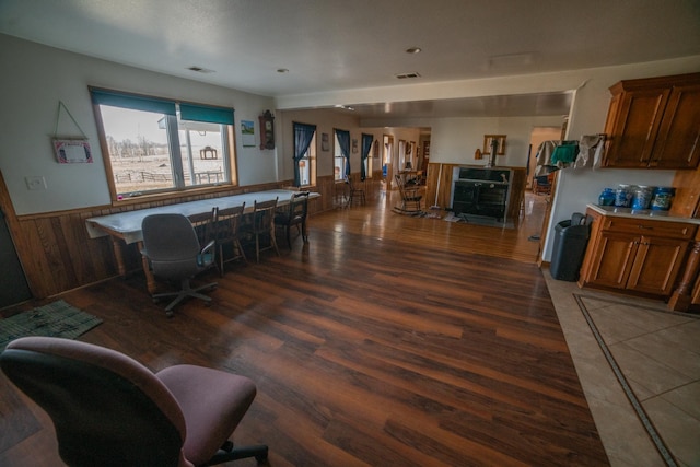 interior space featuring visible vents, wooden walls, wood finished floors, and a wainscoted wall