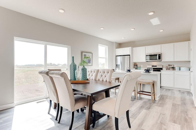 dining area with light wood-type flooring and recessed lighting