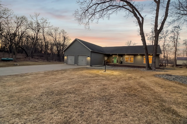 view of front of property with roof with shingles, an attached garage, and driveway