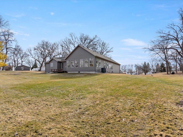 view of property exterior with central air condition unit and a yard
