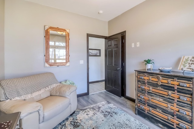 sitting room with baseboards and wood finished floors