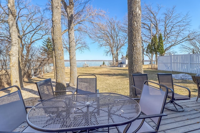 deck with a yard, a water view, and outdoor dining area
