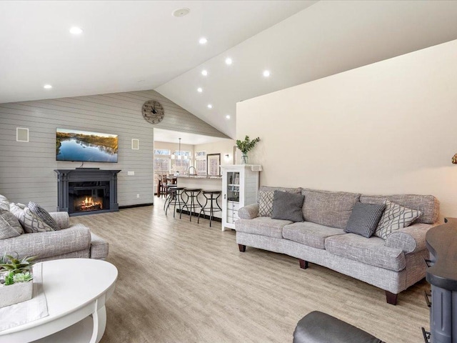 46747 Poss Beach Rd, Pelican Rapids, MN 56572 - living area with wood finished floors, a glass covered fireplace, recessed lighting, high vaulted ceiling, and wooden walls