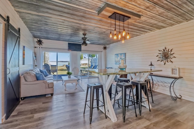 46747 Poss Beach Rd, Pelican Rapids, MN 56572 - dining space with a barn door, wood ceiling, wood finished floors, and wood walls