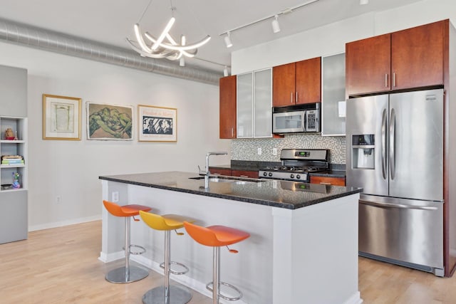 2840 Bryant Ave S Unit E302, Minneapolis, MN 55408 - kitchen with appliances with stainless steel finishes, light wood-style flooring, track lighting, and decorative backsplash