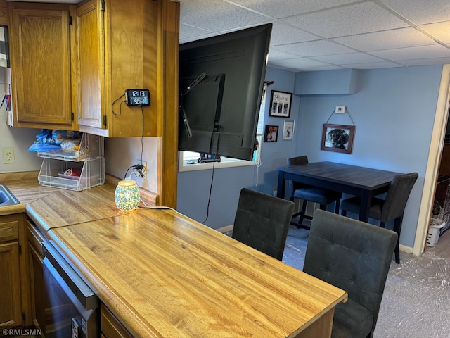 dining room featuring a drop ceiling and baseboards