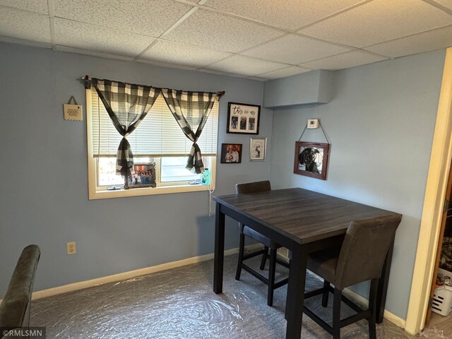 dining area with a drop ceiling and baseboards