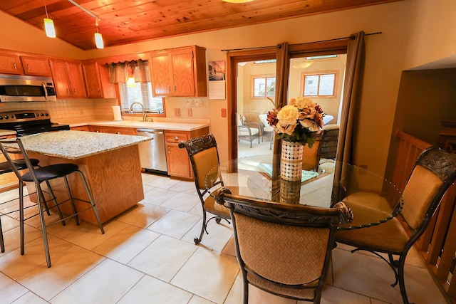 13720 Georgia Dr, Apple Valley, MN 55124 - kitchen with stainless steel appliances, wooden ceiling, decorative backsplash, brown cabinets, and a center island