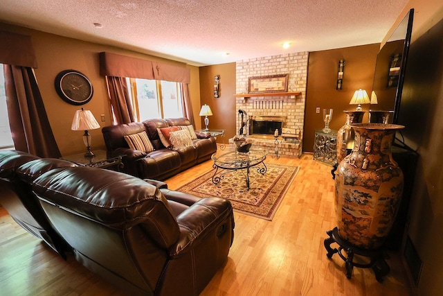 13720 Georgia Dr, Apple Valley, MN 55124 - living area featuring a textured ceiling, wood finished floors, and a brick fireplace