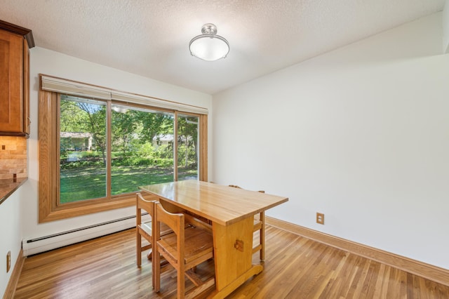 11413 Christansen Ct, Burnsville, MN 55337 - dining space with a baseboard radiator, light wood-style floors, baseboards, and a textured ceiling