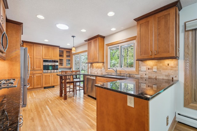 11413 Christansen Ct, Burnsville, MN 55337 - kitchen with a baseboard heating unit, stainless steel appliances, light wood-style flooring, brown cabinets, and a sink