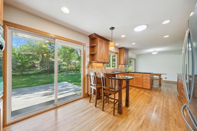 11413 Christansen Ct, Burnsville, MN 55337 - kitchen with freestanding refrigerator, a peninsula, light wood-style floors, open shelves, and a sink
