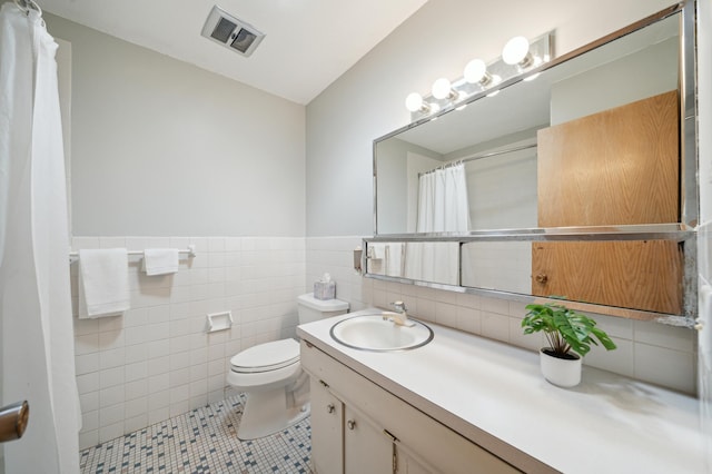 11413 Christansen Ct, Burnsville, MN 55337 - bathroom with toilet, tile patterned flooring, vanity, tile walls, and a wainscoted wall