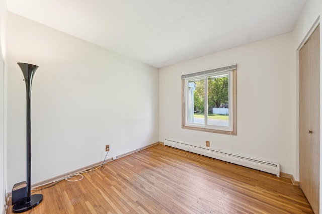 11413 Christansen Ct, Burnsville, MN 55337 - unfurnished bedroom with a baseboard radiator, light wood finished floors, baseboards, and a closet