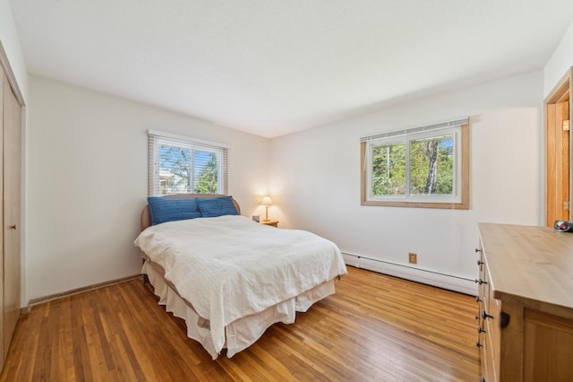 11413 Christansen Ct, Burnsville, MN 55337 - bedroom featuring a baseboard heating unit, light wood-style floors, and a closet
