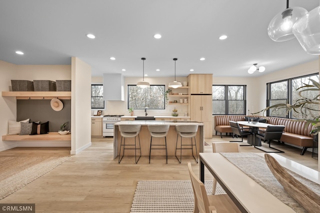 interior space featuring light countertops, a center island, white gas range, open floor plan, and a wealth of natural light