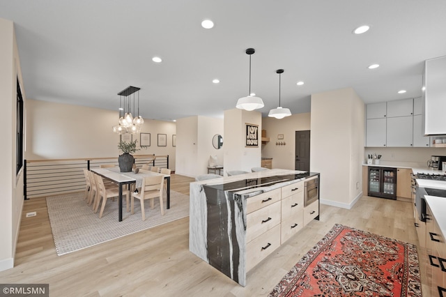 kitchen featuring a center island, recessed lighting, light wood finished floors, and decorative light fixtures
