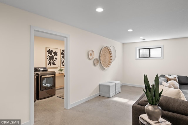 living area with baseboards, recessed lighting, washer / dryer, and finished concrete flooring
