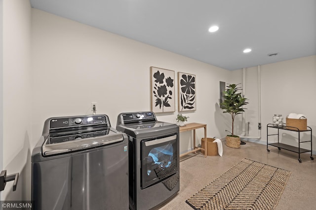 laundry room with baseboards, laundry area, washing machine and dryer, and recessed lighting