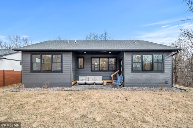 view of front of property featuring a front yard, an outdoor living space, and roof with shingles