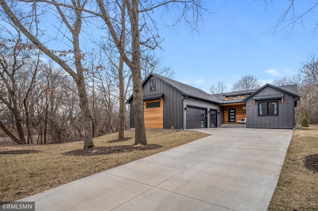 view of front facade with a shingled roof, an attached garage, board and batten siding, and concrete driveway