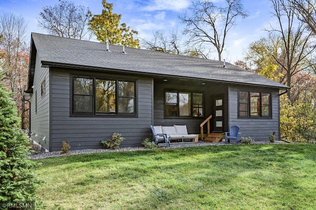 rear view of property featuring a yard, a shingled roof, and entry steps