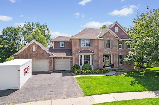 17397 73rd Pl N, Maple Grove, MN 55311 - view of front of property with driveway, an attached garage, a front lawn, brick siding, and roof with shingles
