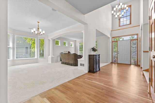 17397 73rd Pl N, Maple Grove, MN 55311 - foyer entrance with a chandelier, decorative columns, light wood-style flooring, arched walkways, and ornamental molding