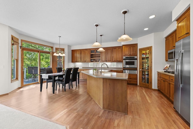 17397 73rd Pl N, Maple Grove, MN 55311 - kitchen with stainless steel appliances, brown cabinetry, open shelves, light wood finished floors, and a chandelier