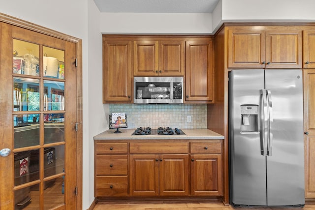 17397 73rd Pl N, Maple Grove, MN 55311 - kitchen featuring appliances with stainless steel finishes, brown cabinets, tasteful backsplash, and light countertops