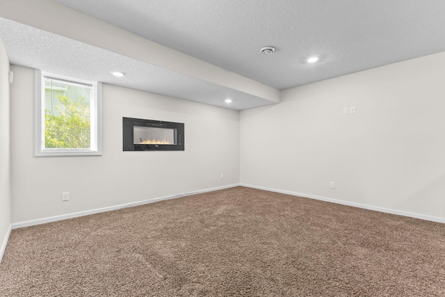 17397 73rd Pl N, Maple Grove, MN 55311 - basement featuring carpet flooring, a glass covered fireplace, a textured ceiling, and recessed lighting