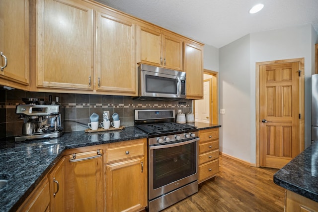 kitchen featuring baseboards, dark wood finished floors, appliances with stainless steel finishes, and backsplash