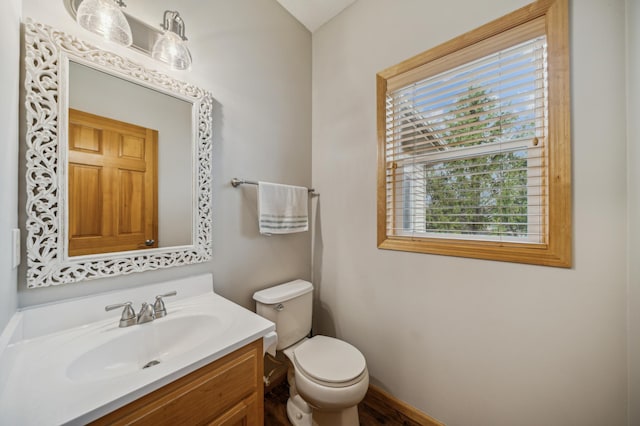 bathroom with vanity, baseboards, wood finished floors, and toilet
