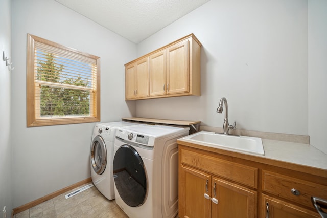 laundry room featuring a textured ceiling, visible vents, cabinet space, a sink, and washer and dryer