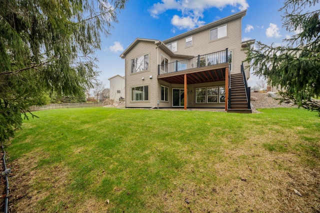 back of property featuring fence, a wooden deck, a yard, and stairway