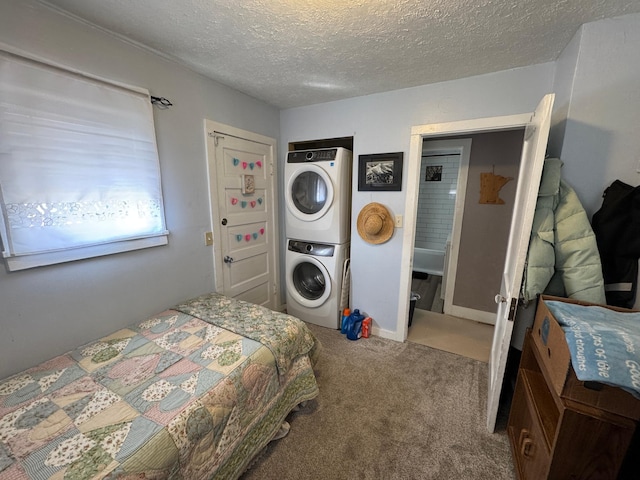 carpeted bedroom featuring stacked washer and clothes dryer and a textured ceiling
