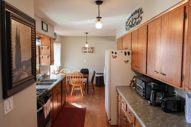 713 Elm Ave, Gaylord, MN 55334 - kitchen featuring black gas range oven, a sink, wood finished floors, stainless steel dishwasher, and brown cabinets