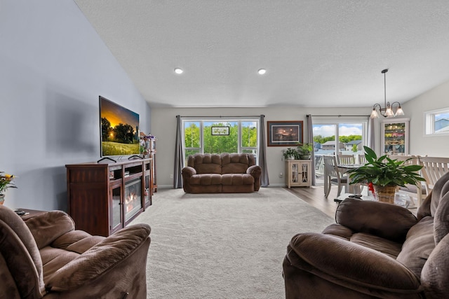 941 Whiskey Rd NW, Isanti, MN 55040 - living room with a chandelier, a textured ceiling, carpet floors, vaulted ceiling, and recessed lighting