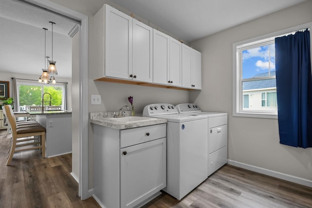 941 Whiskey Rd NW, Isanti, MN 55040 - laundry area featuring washer and dryer, cabinet space, wood finished floors, and baseboards