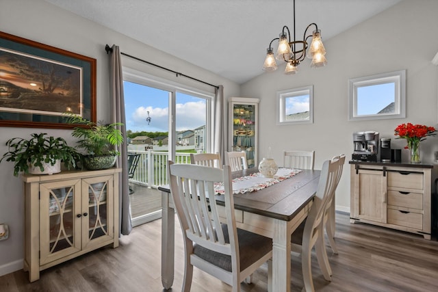 941 Whiskey Rd NW, Isanti, MN 55040 - dining area featuring wood finished floors, vaulted ceiling, a chandelier, and baseboards
