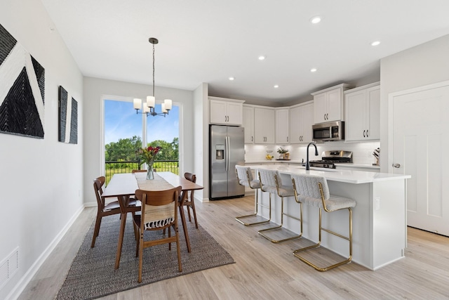 6767 Bluestem Way, Minnetrista, MN 55331 - kitchen with stainless steel appliances, a chandelier, light countertops, light wood-style flooring, and recessed lighting