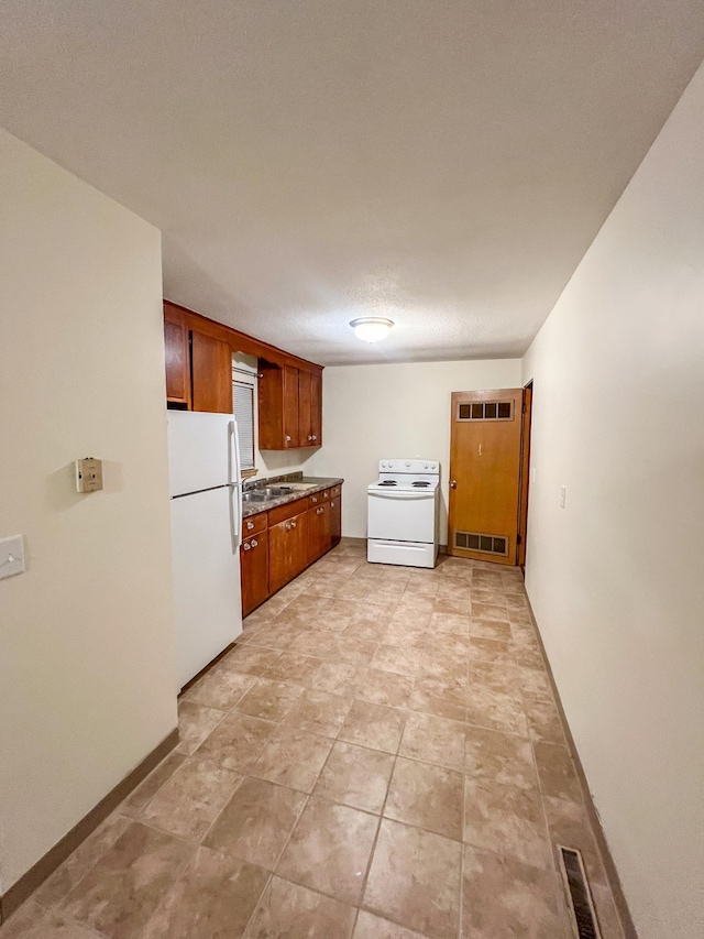 302 Elmwood St, Arlington, MN 55307 - kitchen featuring white appliances, brown cabinets, a sink, and baseboards
