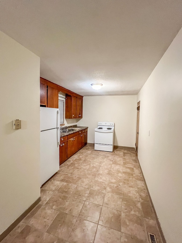 302 Elmwood St, Arlington, MN 55307 - kitchen featuring white appliances, brown cabinets, a sink, and baseboards