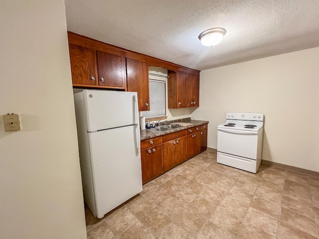 302 Elmwood St, Arlington, MN 55307 - kitchen featuring white appliances, a sink, dark countertops, a textured ceiling, and brown cabinetry