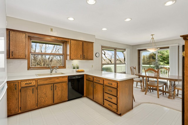 kitchen featuring dishwasher, a sink, a peninsula, brown cabinetry, and recessed lighting